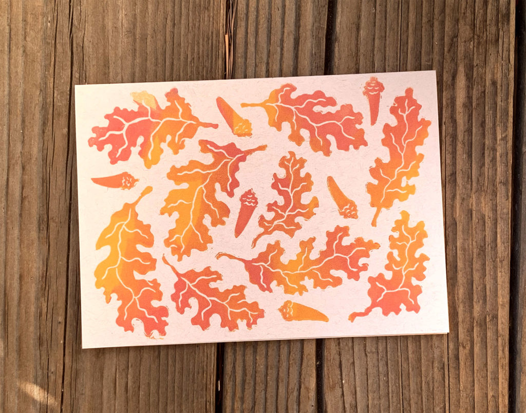 linocut of swirl of oak leaves in gradient red orange and yellow