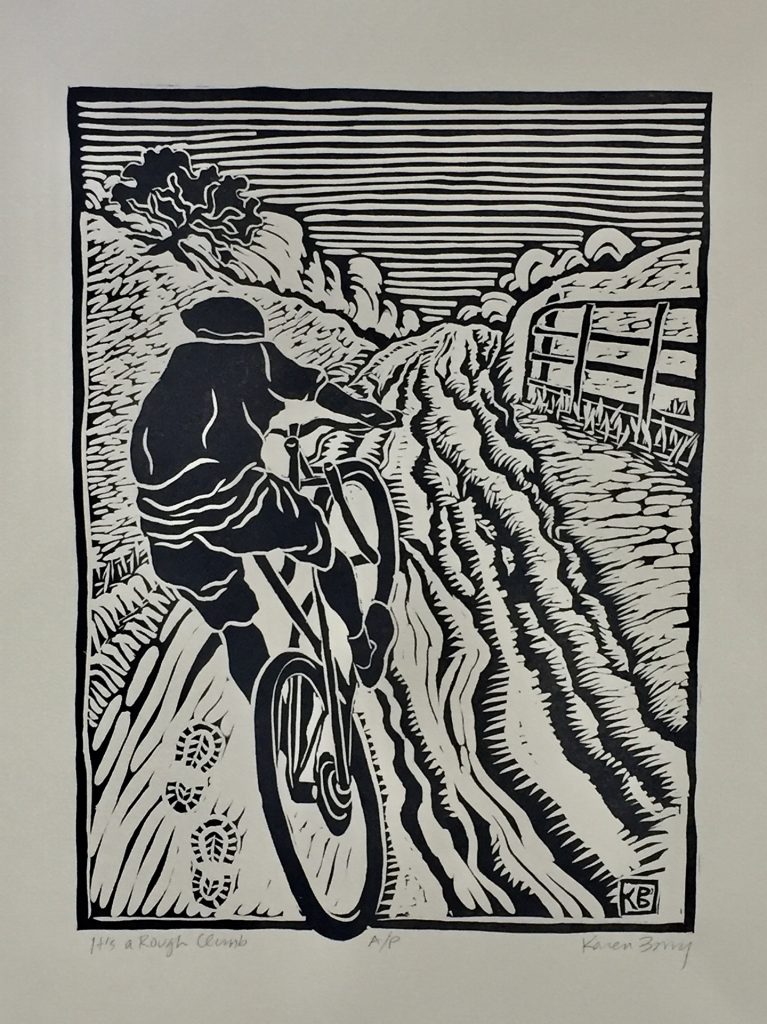 linocut of mountain bike rider riding up a rough dirt road