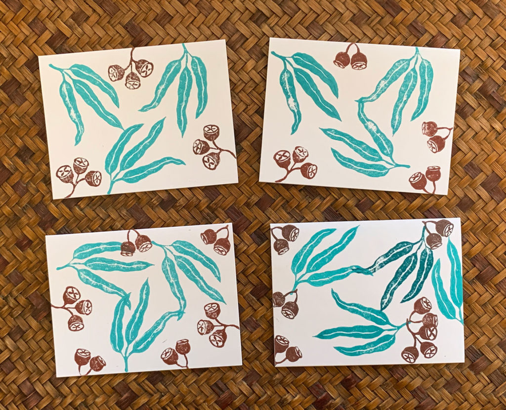 linocut notecard of eucalyptus leaves and seed printed in turquoise and brown