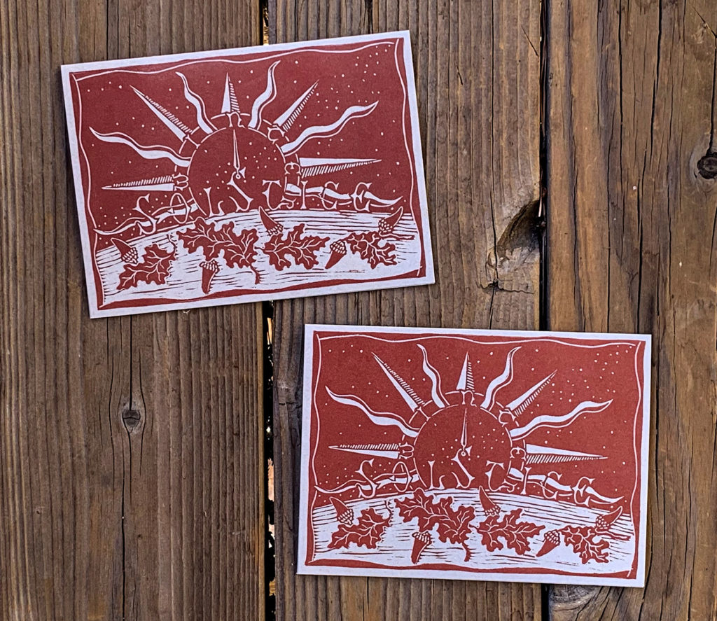 linocut note card of night sky with stars compass sun rays oak leaves acorns in dark red