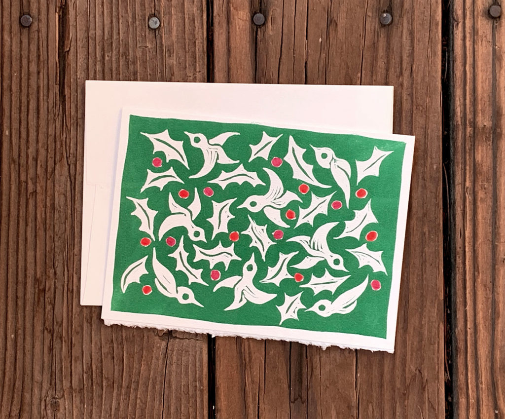 linocut notecard of pattern of birds holly leaves and berries green and red